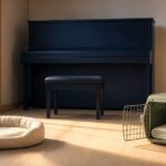 おじさまと猫3巻 閉じた紺色のピアノと空の猫用ベッド・開いたキャリーに同じ朝の光が届くアイキャッチ画像